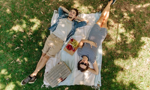 July Blog Couple laying down under the shade