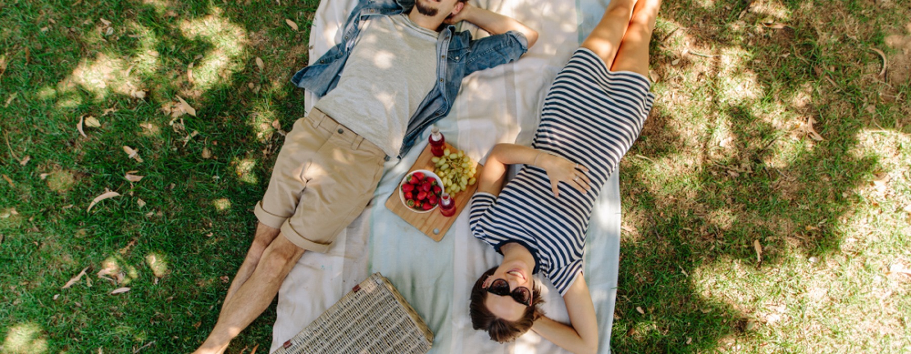 Couple laying under shade on the grass